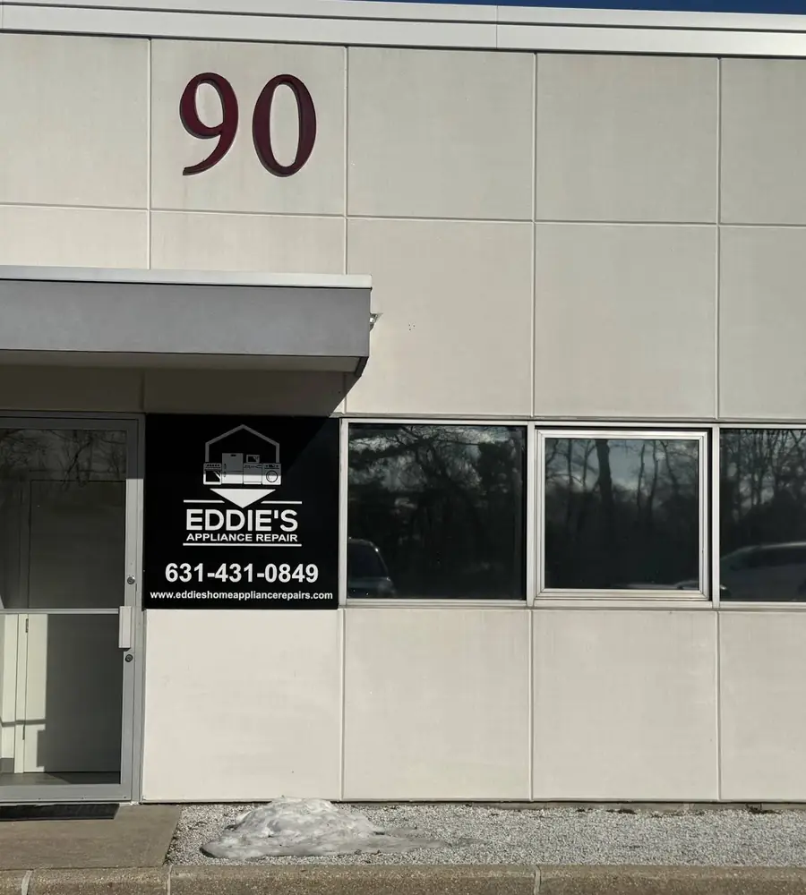 Eddie's Appliance Repair sign and phone number on the building at 90 Cain Drive in Brentwood