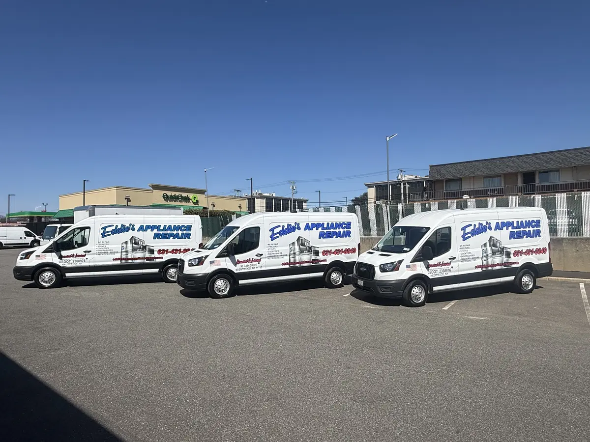 Three white Eddie's Appliance Repair service vans parked side by side